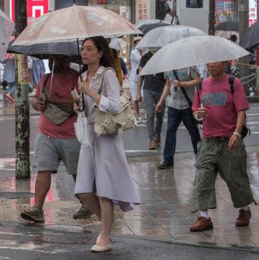 Tokyo, Japonya - 29 Temmuz 2018. Yaya Shinjuku sokakta şemsiye ile yağmurda yürüme.