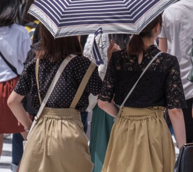 Tokyo, Japonya - 19 Ağustos 2018. Sıcak bir yaz günü Shibuya içinde sırasında şemsiye ile Japon kızlar.