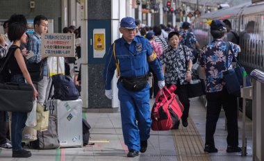 Tokyo, Japonya - 17 Ağustos 2018. Japon demiryolu şirketi güvenlik görevlisi Tokyo Tren İstasyonu yürüme.