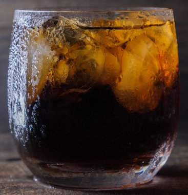 Bir bardak kola içkiler ahşap masa üstü buz ile