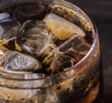 Ahşap masa üstü buz ile bir bardak kola içecek yakın çekim