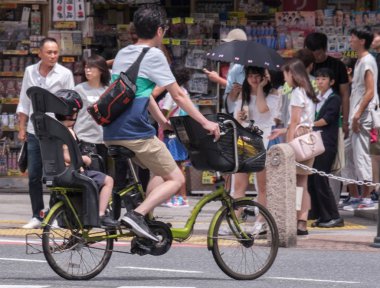 Tokyo, Japonya - 19 Ağustos 2018. Japon baba çocuğunu Shibuya sokakta bir bisiklet sürme.