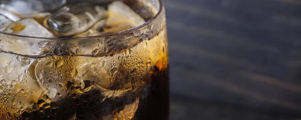 在玻璃杯中关闭可乐饮料 在木桌上加冰块 — 图库照片