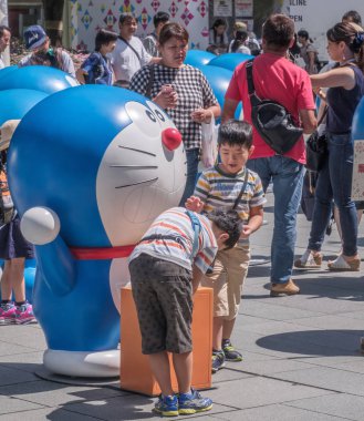 Tokyo, Japonya - 20 Ağustos 2018. Doraemon heykeller Roppongi Hills için yapılan kalabalık çocuk.
