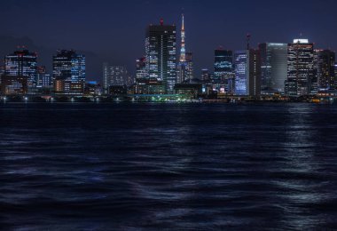 Tokyo, Japonya - 29 Haziran 2019. Tsukuda yüksek katlı binalar, Akşam yemeği cruise houseboat ile Tokyo (yerel yakabutane olarak da bilinir) sumida nehrinde alacakaranlıkta ön planda seyir