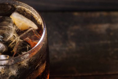 Ahşap masa üstü buz ile bir bardak kola içecek yakın çekim