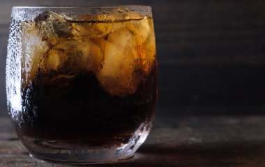 Bir bardak kola içkiler ahşap masa üstü buz ile