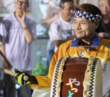 Tokyo, Japonya - 19 Ağustos 2018. Geleneksel taiko oynarken müzisyen eşlik eden dans topluluğu Shimokitazawa Awa Odori Festivali sırasında sokakta davul.