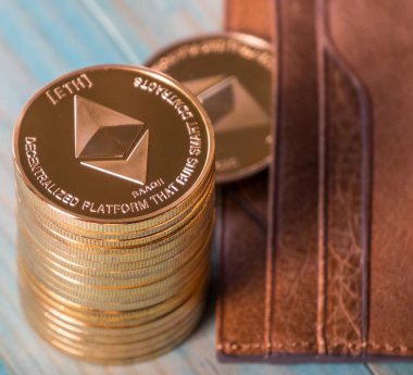 Ahşap masa üzerinde deri cüzdan ile Ethereum sikkeler