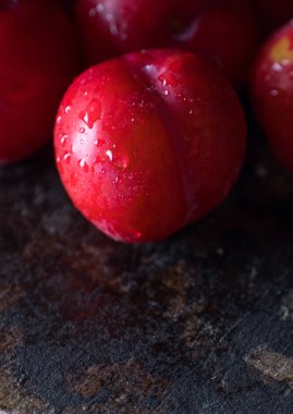 Koyu ahşap arka plan üzerinde kırmızı erik