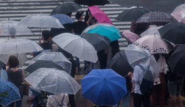 Tokyo, Japonya - 29 Temmuz 2018. Yaya Shinjuku sokakta şemsiye ile yağmurda yürüme.
