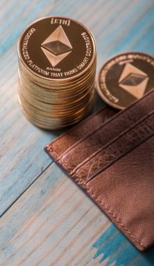 Ahşap masa üzerinde deri cüzdan ile Ethereum sikkeler