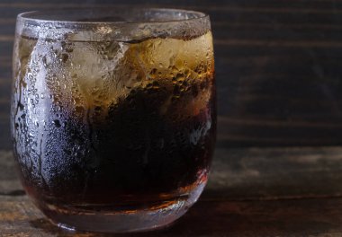 Bir bardak kola içkiler ahşap masa üstü buz ile