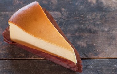 Ahşap masa üstüne peynir pasta bir dilim