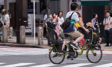 Tokyo, Japonya - 19 Ağustos 2018. Japon baba çocuğunu Shibuya sokakta bir bisiklet sürme.