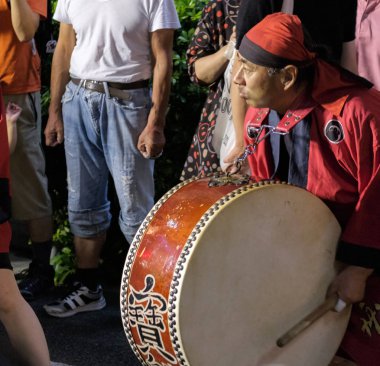 Tokyo, Japonya - 19 Ağustos 2018. Geleneksel taiko oynarken müzisyen eşlik eden dans topluluğu Shimokitazawa Awa Odori Festivali sırasında sokakta davul.