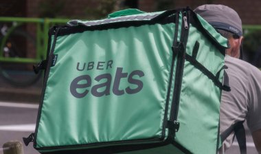 Tokyo, Japonya - 19 Ağustos 2018. Uber yiyor binici Shibuya Caddesi Bisiklete binme.