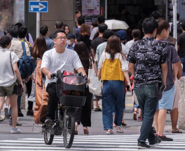 Tokyo, Japonya - 19 Ağustos 2018. Japon baba çocuğunu sokakta Shibuya ile yeni bisiklet sürme.