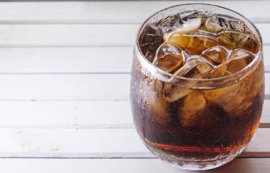Bir bardak kola içkiler ahşap masa üstü buz ile