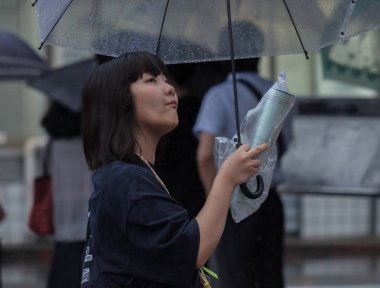 Tokyo, Japonya - 29 Temmuz 2018. Shibuya içinde yağmurlu tayfun sezonunda şemsiye ile Japon kız.