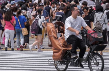 Tokyo, Japonya - 19 Ağustos 2018. Japon baba çocuğunu sokakta Shibuya ile yeni bisiklet sürme.