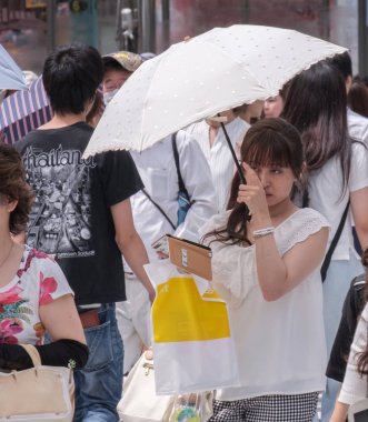 Tokyo, Japonya - 19 Ağustos 2018. Sıcak bir yaz günü Shibuya içinde sırasında şemsiye ile Japon kadın.