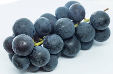 Beyaz arka plan üzerinde olgunlaşmış taze siyah üzüm