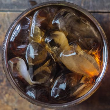 Bir bardak kola içkiler ahşap masa üstü buz ile