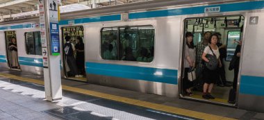 Tokyo, Japonya - 17 Ağustos 2018. Commuters gemide bir tren Tokyo Tren İstasyonu platformu.