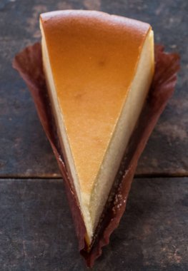 Ahşap masa üstüne peynir pasta bir dilim