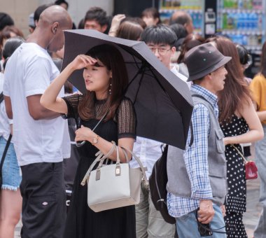 Tokyo, Japonya - 19 Ağustos 2018. Sıcak bir yaz günü Shibuya içinde sırasında şemsiye ile Japon kadın.