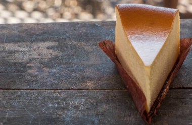 Ahşap masa üstüne peynir pasta bir dilim