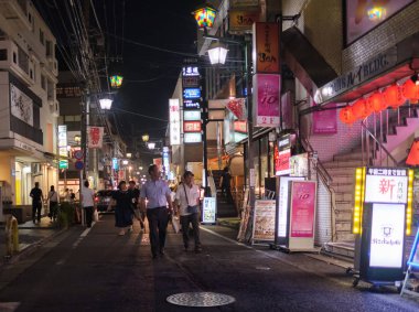 Tokyo, Japonya - 12 Ağustos 2018. Backstreet Shimokitazawa mahalle geceleri sokak yürüyüş insanlar.
