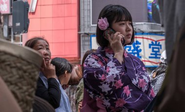 Tokyo, Japonya - 19 Ağustos 2018. Trditional yukata güzel Japon kız ile smartphone Shibuya sokakta.