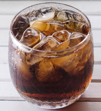 Bir bardak kola içkiler ahşap masa üstü buz ile