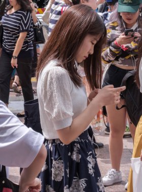 Tokyo, Japonya - 19 Ağustos 2018. Shibuya içinde karşıdan karşıya bekleyen smartphone ile Japon kız.