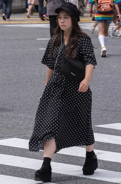 Tokyo, Japonya - 19 Ağustos 2018. Japon kız onun smartphone geçiş Street'in Shibuya içinde musci dinlerken.