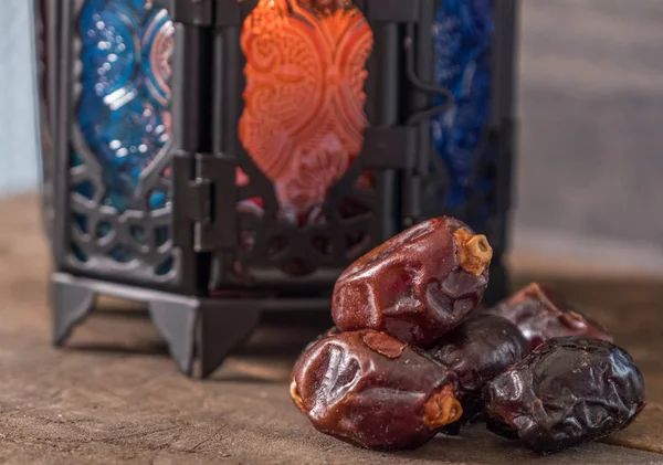 Ahşap masada mum fener ile Tarihler meyve