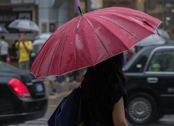 Tokyo, Japonya - 29 Temmuz 2018. Shibuya içinde yağmurlu tayfun sezonunda şemsiye ile Japon kız.