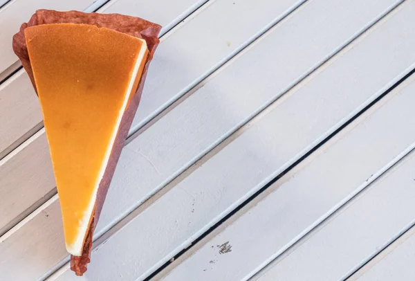 Ahşap masa üstüne peynir pasta bir dilim