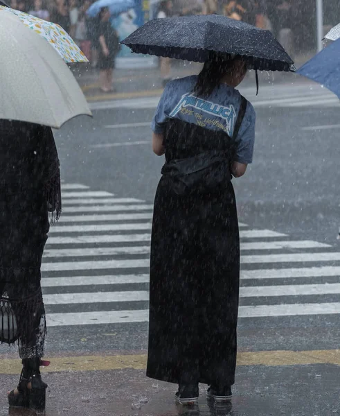 Tokyo, Japonya - 29 Temmuz 2018. Shibuya içinde yağmurlu tayfun sezonunda şemsiye ile Japon kız.