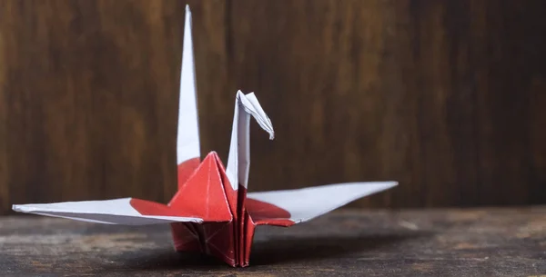 Japanese flag origami paper crane on wooden table top