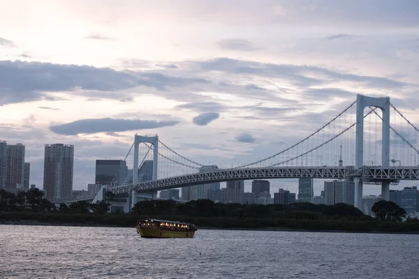 Tokyo, Japonya - 15 Ağustos 2018. Akşam yemeği cruise gemi, veya yerel olarak Gökkuşağı Köprüsü ile ndusk içinde belgili tanımlık geçmiş vasıl Sumida nehir boyunca yelken yakatabune olarak bilinen.