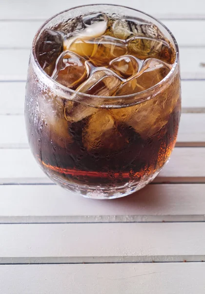 木製のテーブルの上に氷をグラスにコーラ飲料 — ストック写真