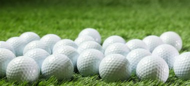 Yeşil çimenlerin üzerinde golf topları