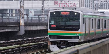 Tokyo, Japonya - 16 Eylül 2018. Bir ışık sabah çiseleyen yağmur sırasında Shonan Shinjuku banliyö treni Yurakucho İstasyonu.
