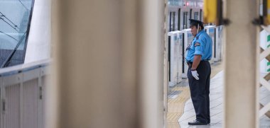 Tokyo, Japonya - 16 Eylül 2018. Yurakucho Tren İstasyonu güvenlik görevlisi terminal platformunda iş başında.