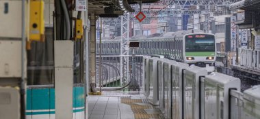 Tokyo, Japonya - 16 Eylül 2018. Işık sabah çiseleyen yağmur sırasında Japonya demiryolu Yamanote satır banliyö treni Yurakucho İstasyonu.