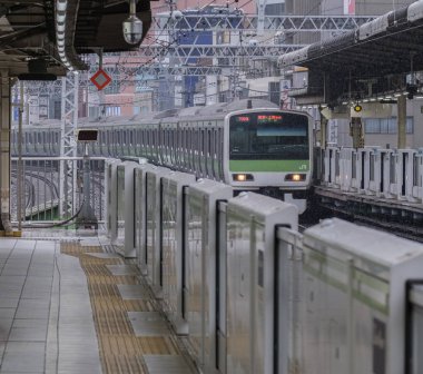 Tokyo, Japonya - 16 Eylül 2018. Işık sabah çiseleyen yağmur sırasında Japonya demiryolu Yamanote satır banliyö treni Yurakucho İstasyonu.