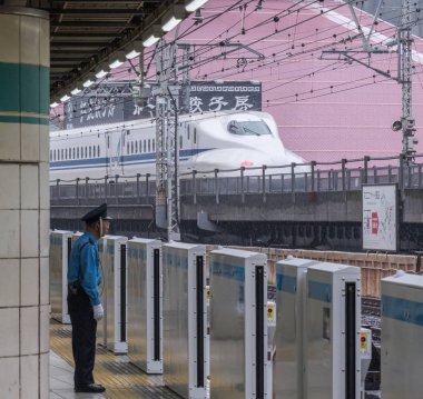 Tokyo, Japonya - 16 Eylül 2018. Yurakucho Tren İstasyonu güvenlik görevlisi terminal platformunda iş başında.